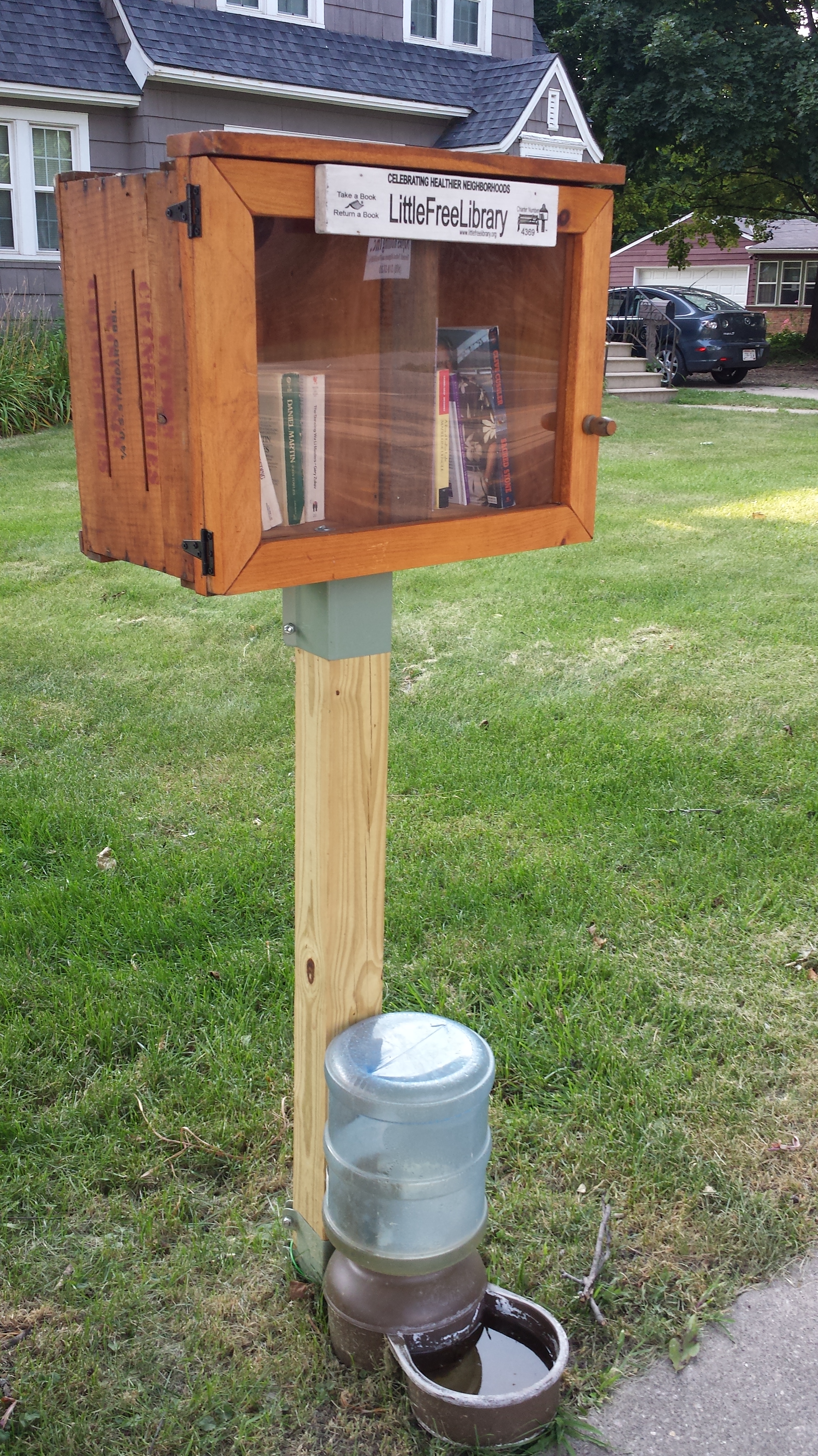 An example of a little lending library with dog water bowl.